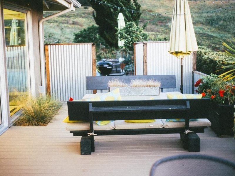 Terrasse en bois avec banc et panneaux de clôture à l'arrière d'une maison