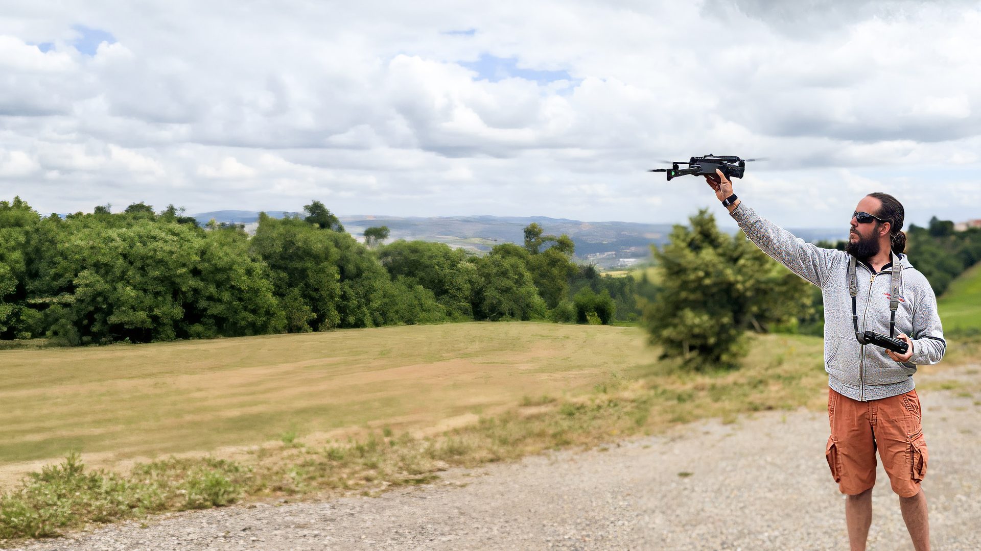 Télépilote lançant un drone au-dessus d'un terrain dégagé